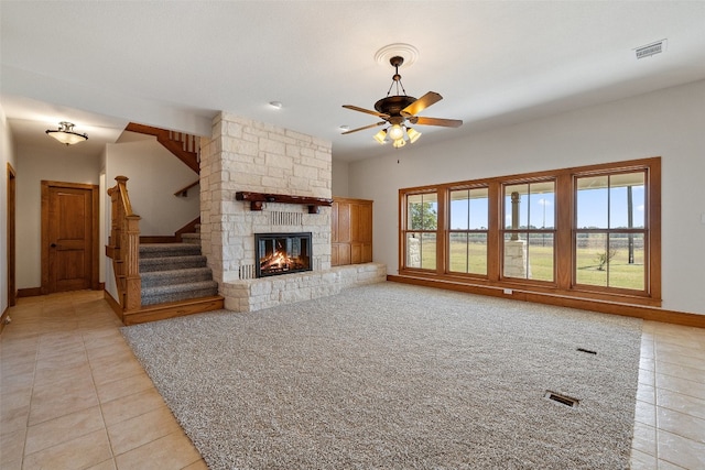 unfurnished living room with ceiling fan, light tile patterned flooring, a fireplace, and vaulted ceiling