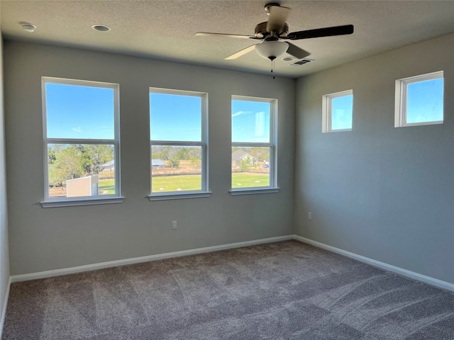 carpeted spare room with ceiling fan and a textured ceiling