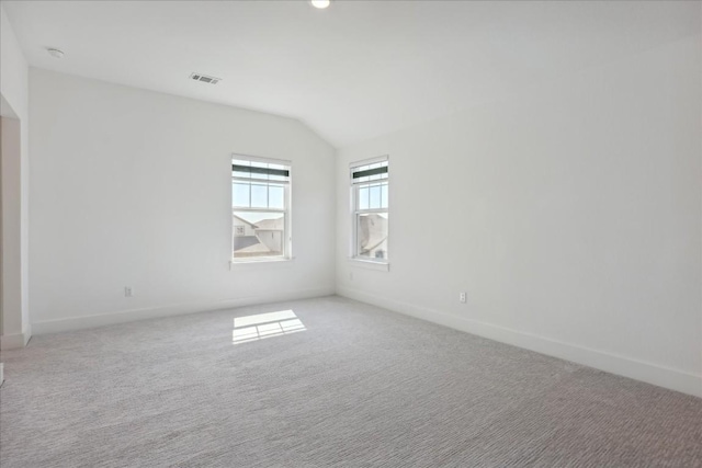 carpeted spare room featuring lofted ceiling