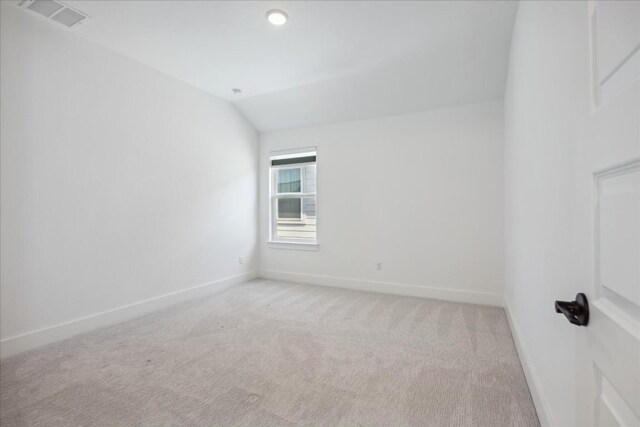 unfurnished room with light carpet and lofted ceiling