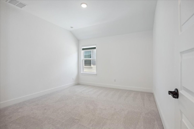 unfurnished room with lofted ceiling and light carpet