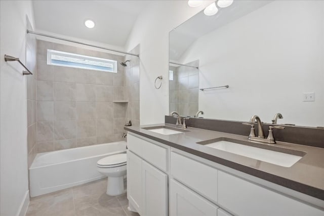 full bathroom featuring vanity, tile patterned floors, toilet, and tiled shower / bath