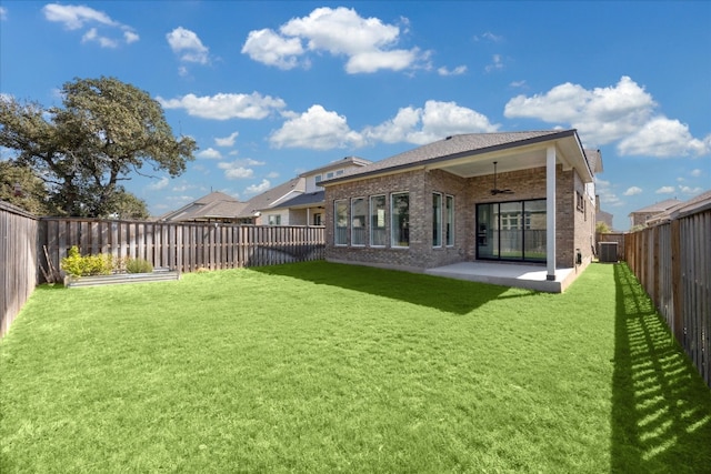 back of property with central AC unit, ceiling fan, a patio area, and a lawn