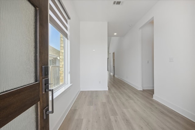 hallway with a healthy amount of sunlight and light wood-type flooring