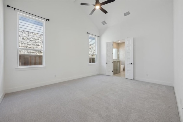 unfurnished bedroom featuring ceiling fan, ensuite bath, high vaulted ceiling, and light carpet