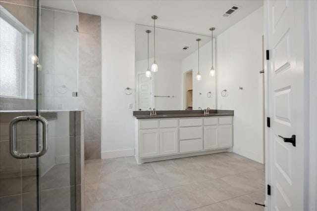 bathroom with vanity, an enclosed shower, and tile patterned flooring