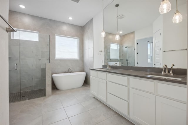 bathroom featuring tile patterned flooring, vanity, tile walls, and shower with separate bathtub