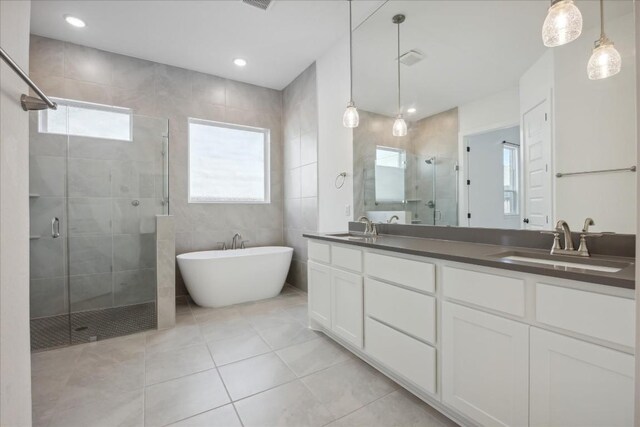 1325 Kneehigh Dr, Georgetown, TX 78633 - full bath with a shower stall, double vanity, a soaking tub, healthy amount of natural light, and tile walls