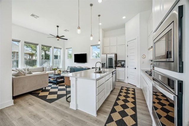 1325 Kneehigh Dr, Georgetown, TX 78633 - kitchen with stainless steel appliances, open floor plan, light wood-style floors, a ceiling fan, and recessed lighting