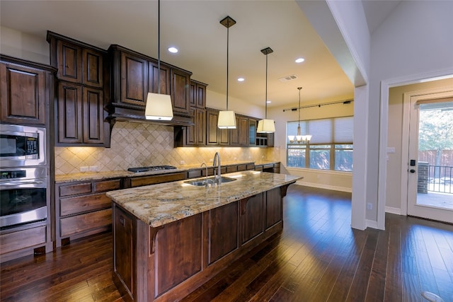 kitchen featuring a kitchen island with sink, dark hardwood / wood-style floors, a kitchen breakfast bar, stainless steel appliances, and sink