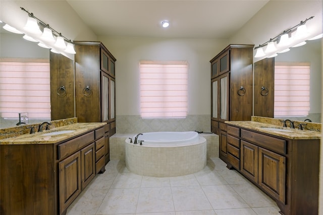 bathroom featuring vanity, tiled bath, and tile patterned flooring