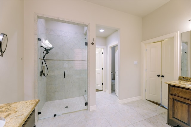 bathroom with vanity, a shower with shower door, toilet, and tile patterned floors