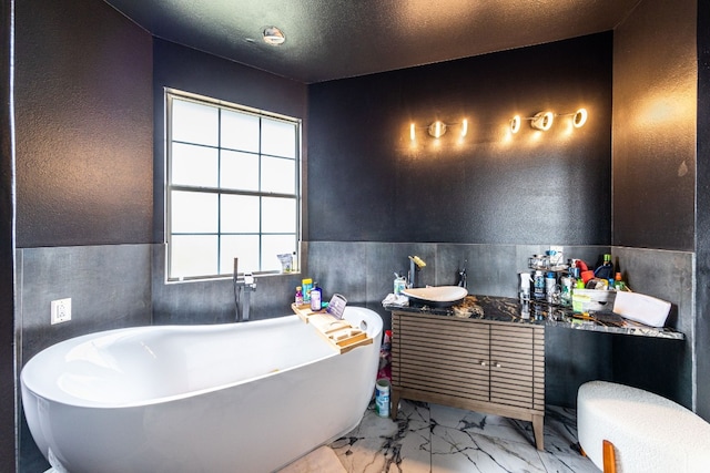 bathroom with vanity, a textured ceiling, and a bath