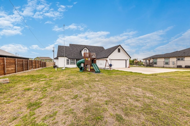 exterior space with a front yard, a playground, and a garage