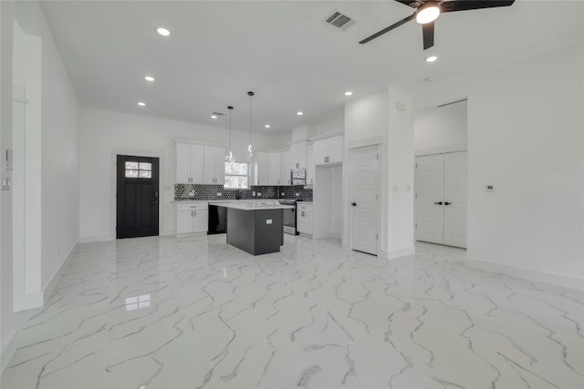 kitchen with white cabinetry, appliances with stainless steel finishes, decorative light fixtures, backsplash, and a center island