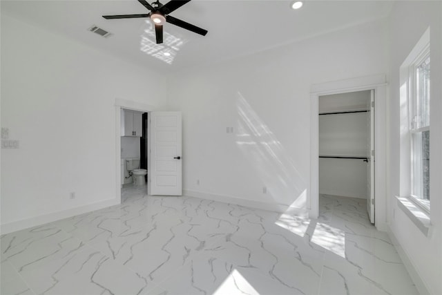 unfurnished bedroom featuring connected bathroom, a closet, multiple windows, and ceiling fan