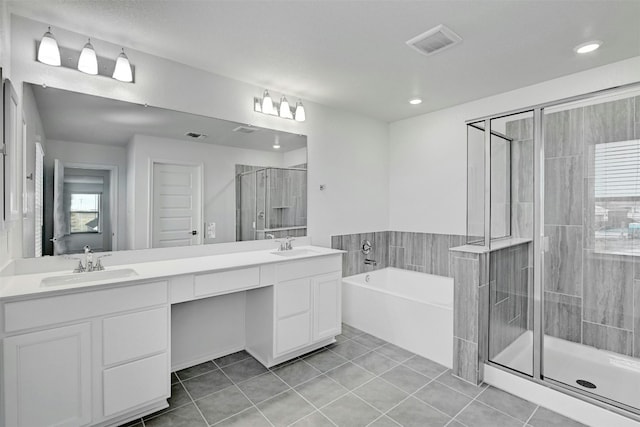 bathroom featuring tile patterned flooring, vanity, plenty of natural light, and plus walk in shower