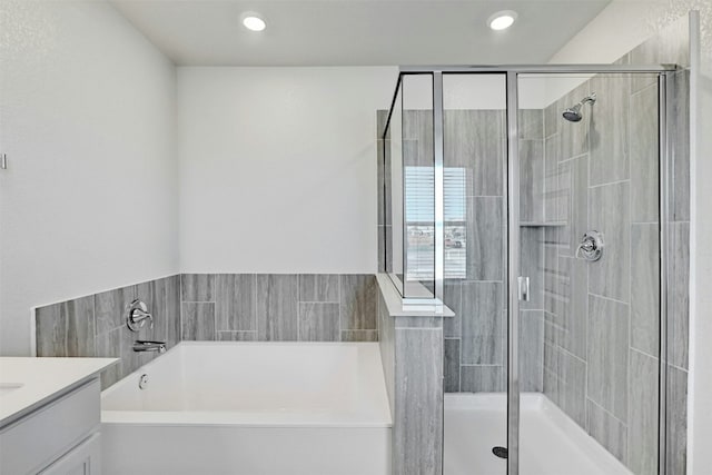 bathroom featuring vanity and shower with separate bathtub