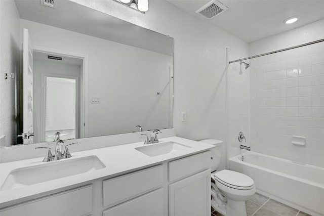 full bathroom featuring tile patterned floors, vanity, tiled shower / bath combo, and toilet