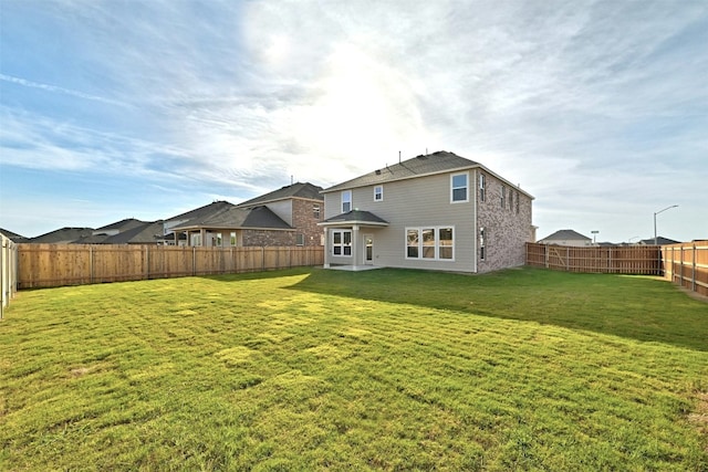 rear view of property featuring a yard