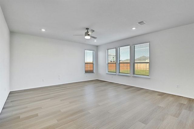 empty room with ceiling fan and light hardwood / wood-style floors