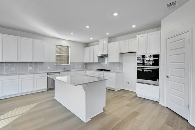 kitchen with a center island, light hardwood / wood-style flooring, and white cabinetry