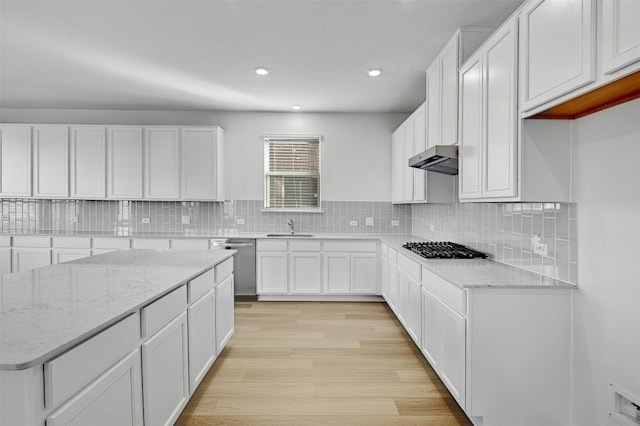 kitchen featuring light stone countertops, sink, gas cooktop, white cabinets, and light wood-type flooring