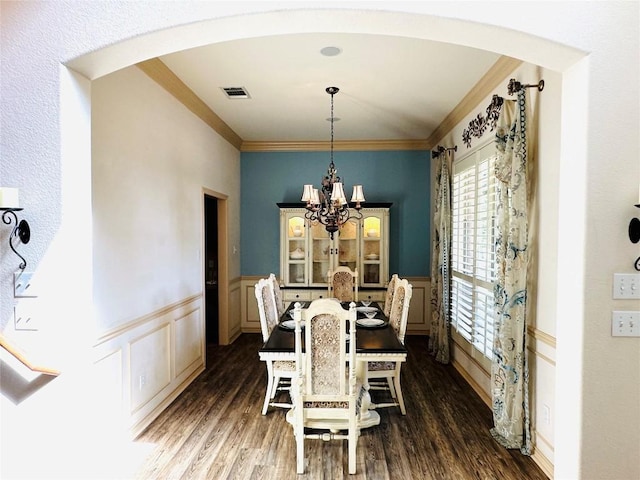 300 Copper Ln, Leander, TX 78641 - dining space with arched walkways, a chandelier, a decorative wall, dark wood finished floors, and ornamental molding