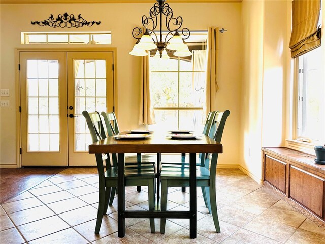 tiled dining area featuring plenty of natural light, a notable chandelier, and french doors