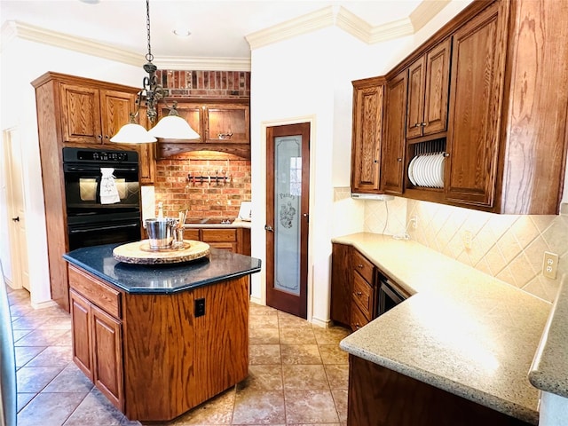 kitchen featuring decorative light fixtures, tasteful backsplash, ornamental molding, a kitchen island, and black appliances