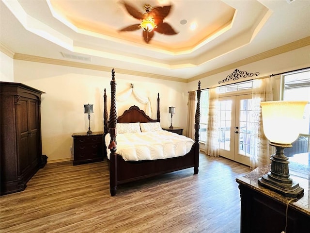 300 Copper Ln, Leander, TX 78641 - bedroom featuring a raised ceiling, access to exterior, french doors, wood finished floors, and crown molding
