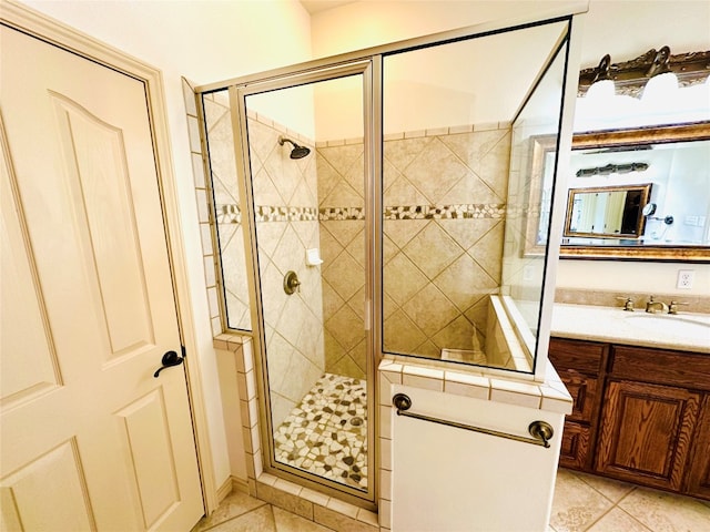 bathroom featuring tile patterned flooring, an enclosed shower, and vanity