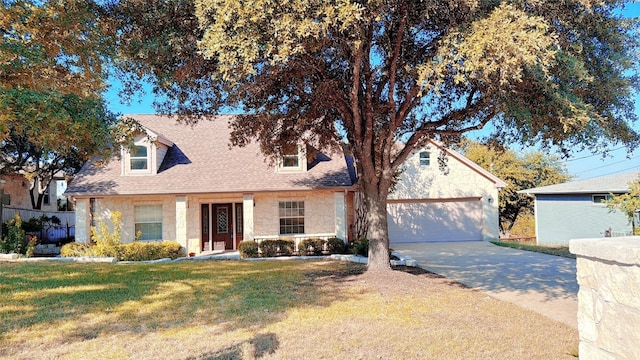 cape cod house with a garage and a front lawn