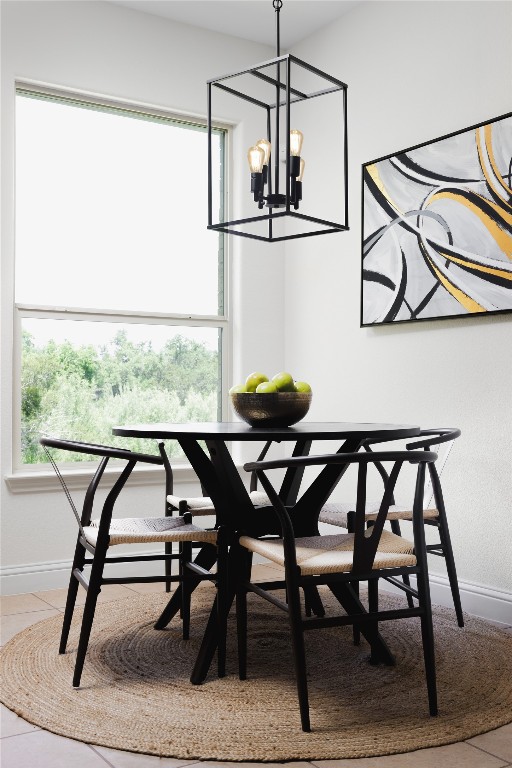 dining area featuring light tile patterned floors, plenty of natural light, and an inviting chandelier