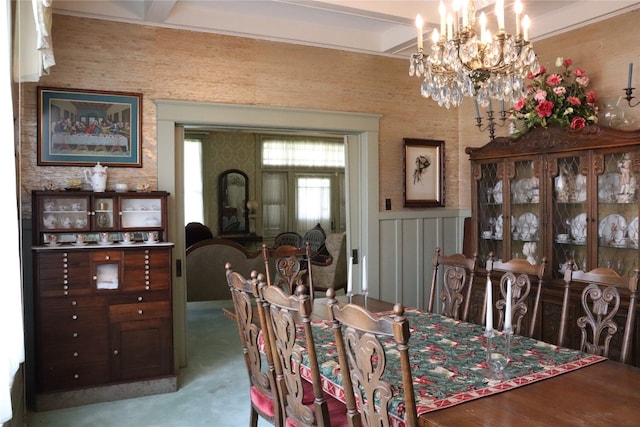 carpeted dining area featuring a notable chandelier and beamed ceiling