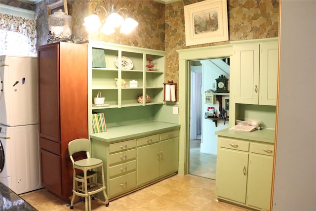 kitchen with stacked washer and clothes dryer and pendant lighting