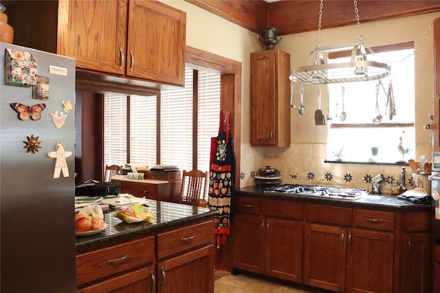 kitchen featuring appliances with stainless steel finishes, hanging light fixtures, and tasteful backsplash