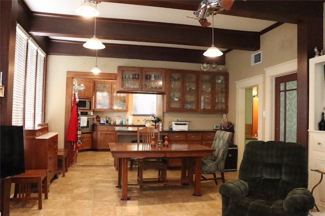 dining space featuring beamed ceiling