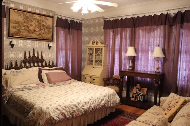 bedroom featuring crown molding, wood-type flooring, and ceiling fan