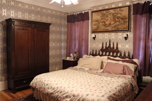 bedroom featuring ornamental molding, wood-type flooring, and ceiling fan