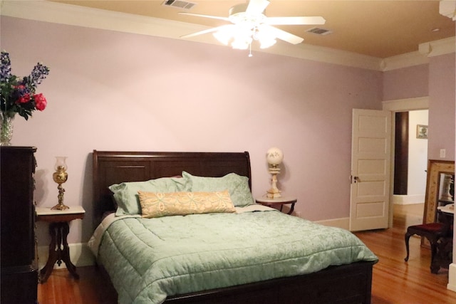 bedroom with crown molding, hardwood / wood-style flooring, and ceiling fan