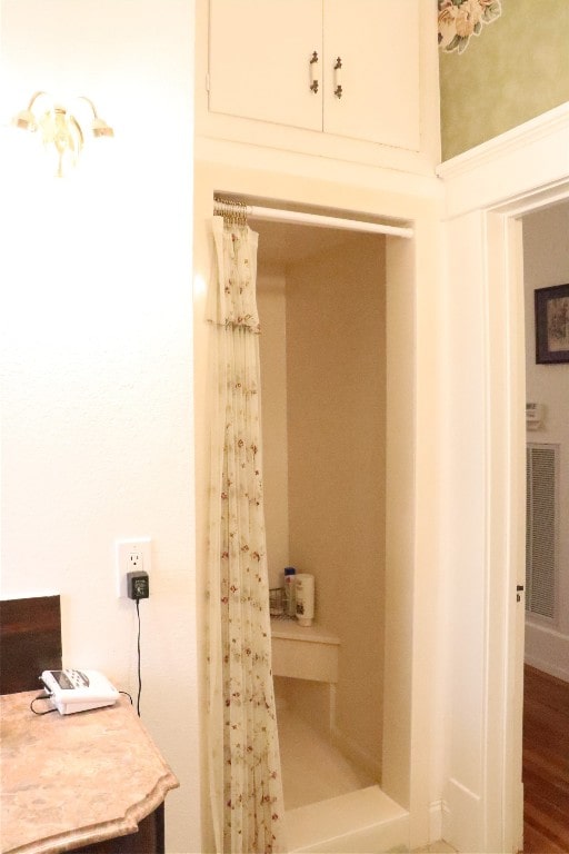 bathroom featuring curtained shower and hardwood / wood-style flooring