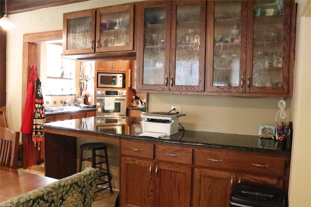 kitchen with a breakfast bar, appliances with stainless steel finishes, and hardwood / wood-style flooring