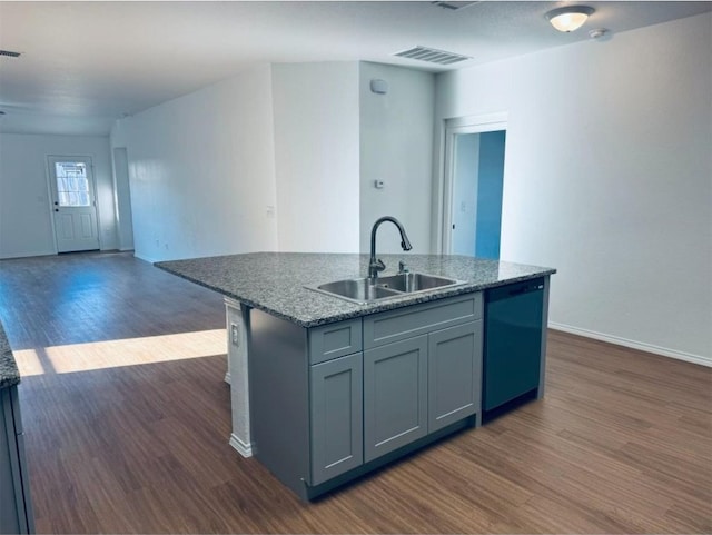 kitchen featuring gray cabinetry, a kitchen island with sink, dark wood-type flooring, sink, and dishwasher