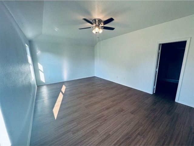 unfurnished room featuring dark hardwood / wood-style floors, vaulted ceiling, and ceiling fan