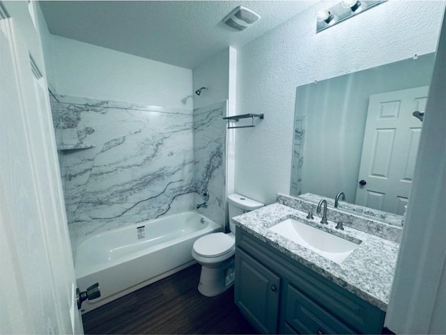 full bathroom featuring a textured ceiling, toilet, hardwood / wood-style flooring, vanity, and tiled shower / bath