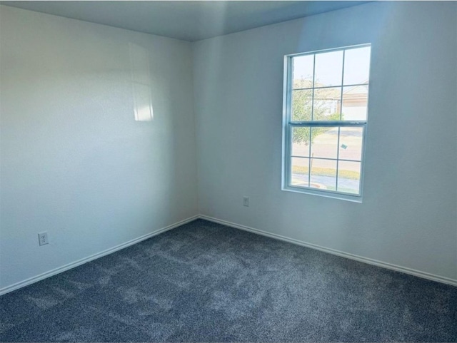 spare room with dark carpet