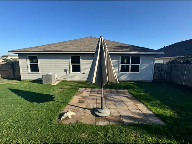 rear view of property featuring a yard and central AC