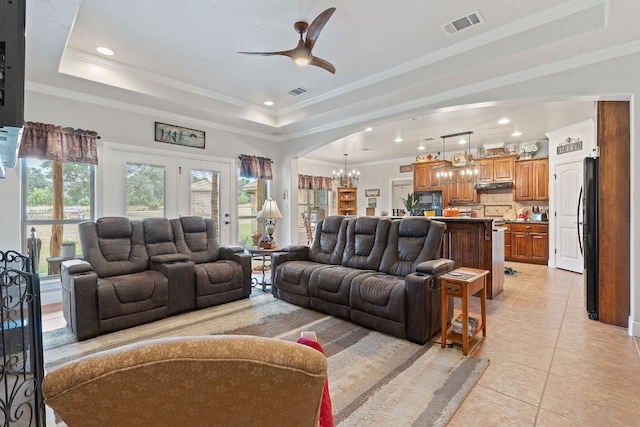 tiled living room with crown molding and a raised ceiling