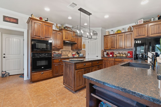 kitchen with black appliances, sink, crown molding, a chandelier, and a center island with sink